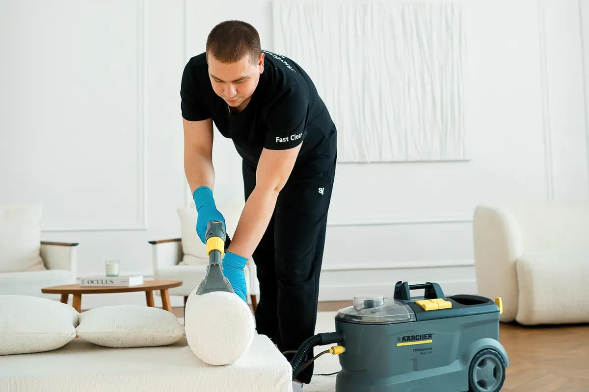 Мастер Fast Clean чистит валик белого дивана экстрактором Karcher